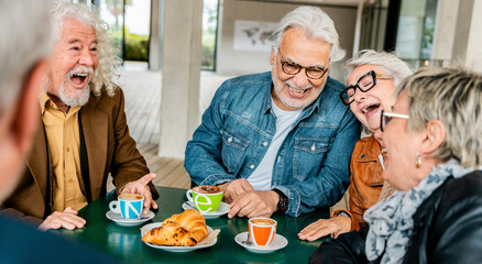 Happy senior people having breakfast sitting at coffee bar - Group of older friends having fun in rooftop restaurant - Life style concept with smiling men and women at cafe terrace