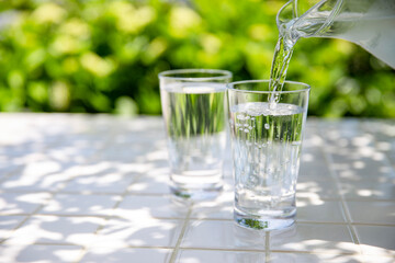 水を注ぐ　木陰のテーブルで冷たいミネラルウォーターを飲む