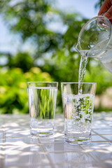 水を注ぐ　木陰のテーブルで冷たいミネラルウォーターを飲む