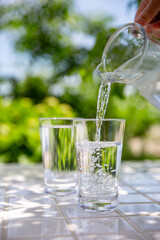水を注ぐ　木陰のテーブルで冷たいミネラルウォーターを飲む