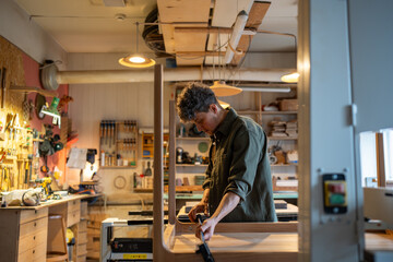Concentrated carpenter working on making a table, using clamping brackets and bar clamps....