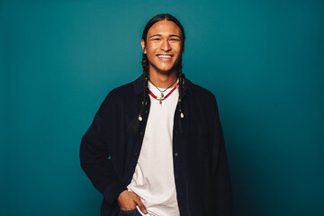 Portrait of a confident native man with braided hair and stylish jewelry