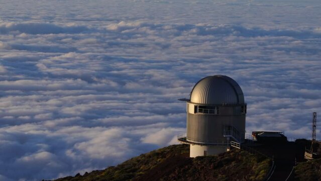 Movimiento rapido o timelapse, y en primer plano el telescopio n&oacute;rdico ubicado en el Roque de Los Muchachos en la isla canaria de La Palma, al fondo, el movimiento del mar de nubes