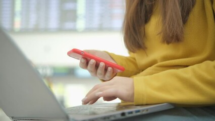 Woman hands answering messages on smartphone in the airport sitting at table. Female waiting in the departure lounge entertaining herself on the phone.
