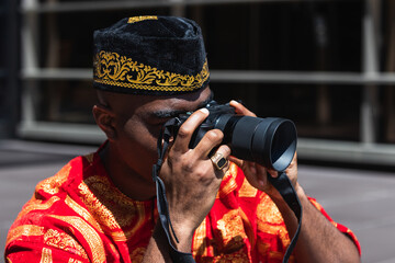 Young man photographer takes photographs with mirrorless camera in a city. Travel, vacations,...