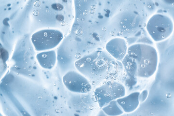 Abstract cosmetic background from transparent gel or antiseptic, hyaluron, macro close up, blue background