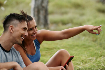 Romantic Couple Planning New Running Routes in the Forest with Smartphone