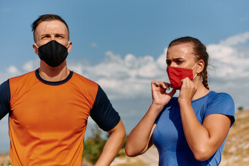 Couple running in nature at morning wearing protective face masks