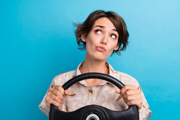 Portrait of minded pensive lady hands hold wheel look empty space brainstorm isolated on blue color...