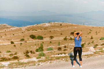 Determined Female Athlete Stretching After an Intense Run Through Rugged Mountain Terrain.