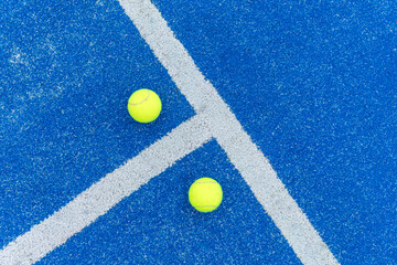overhead view of two balls on a paddle tennis court