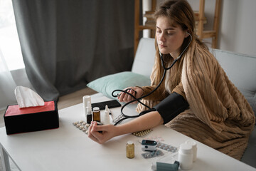 side view of woman measuring blood pressure and pulse. Headache. Disease prevention