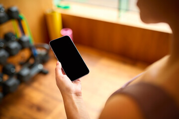 Close Up Shot Of Woman Exercising In Gym Checking Health Monitoring App On Mobile Phone