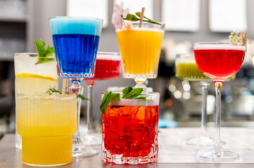 Colorful cocktails arranged on a bar counter, showcasing vibrant hues and garnishes