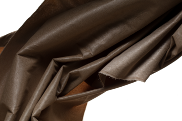 Brown gold canvas fabric flying in curve shape, Piece of textile Brown gold canvas fabric throw fall in air. White background isolated, dark shading environment