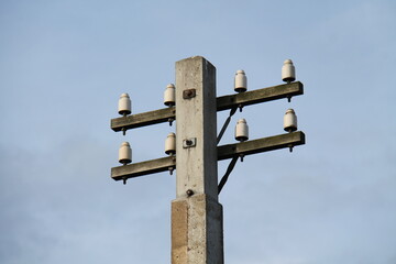 Old Fashioned Telephone Wire Insulators on Concrete Pole.