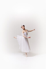 Beautiful woman, ballerina in white dress performs pirouette on pointe, her movements full of grace against white studio background. Concept of art, fusion of classic and modernity, elegance. © Lustre Art Group 