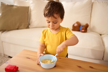 Little boy having healthy meal in the living room