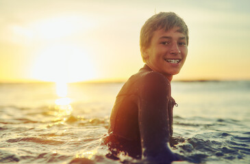 Beach, surfboard and portrait of boy in water for summer holiday, outdoor adventure and weekend in...