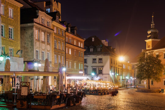 Castle Square (Plac Zamkowy) at night with outdoor seating restaurants around traditional low-rise buildings, Old Town, Warsaw, Poland