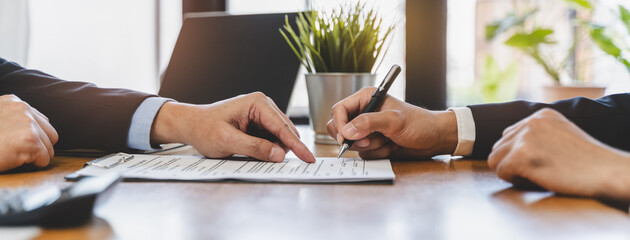 businessman sitting at desk holds pen signing contract paper, lease mortgage, employment hr or...