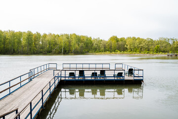 Enjoy the tranquility of a serene lakeside pier surrounded by the beauty of the forest, perfect for...