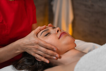 Beautiful young woman undergoing a facial spa massage at a beauty spa. Spa skin and body care....