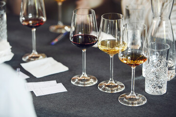 Few full wine glasses with various wine on the table, close up. Serving, service in restaurants. 