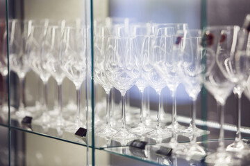 Clean and empty long stemmed elegant wine glasses on storefront, close up. 