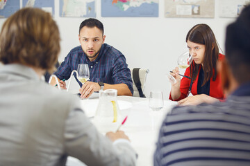 Sommeliers tasting wine at table indoors. Alcoholic beverages degustation courses. Winemaking...