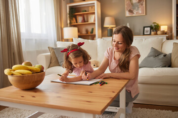 Mother and daughter drawing together at home