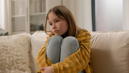 Frustrated depressed little Caucasian child girl preteen daughter hug legs punished bad behavior....