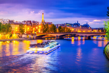 Pont Neuf and Cite island over Seine river with floating boat at night, France, retro toned