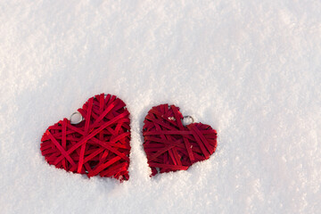 Happy valentines day background with two red hearts on white snow .