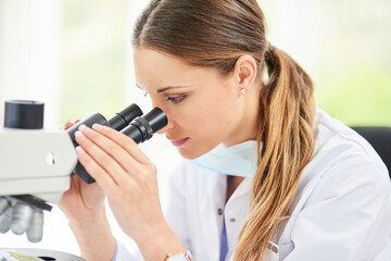 Fototapeta premium Scientist, woman and microscope in laboratory for innovation, experiment and test in clinic. Investigation, chemistry and technology in hospital for healthcare, research and pharmaceutical career