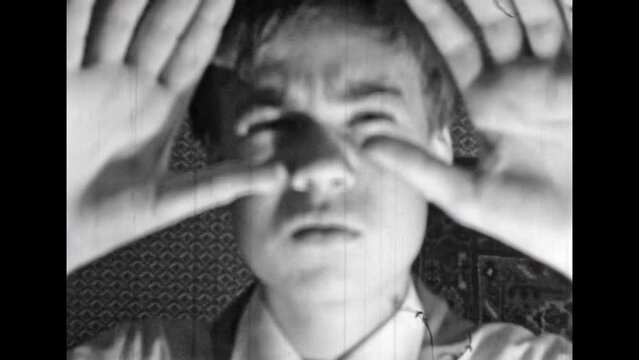 Archive film, boy squinting, seeing poorly portrait, looking at camera, close up. Vintage black white video. Teenager with astigmatism eye disease. Myopia vision in young age problem. Retro 1980s