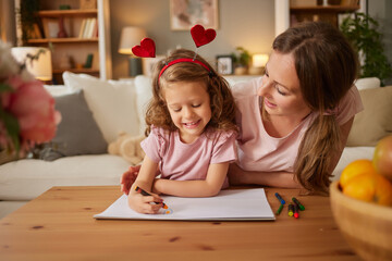 Mother and daughter drawing together at home