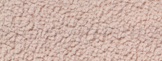 Texture of beige fluffy woolen textile background from soft fleecy material, macro. Structure of brown fabric