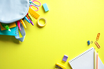 Vibrant back to school supplies on yellow background. Flat lay, top view.