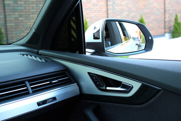 Look in the rearview mirror from inside the car. Rearview car driving mirror. Side rear-view mirror on a modern car. 