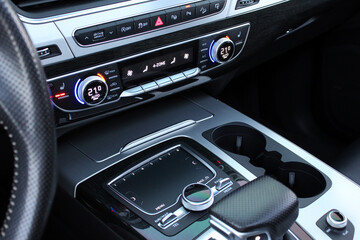 Premium car interior with grey leather trim and aluminum buttons. Climate control with temperature...