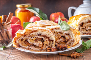 Homemade fragrant autumn apple strudel with caramelized apples, raisins, nuts, honey, cinnamon...