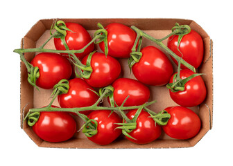 Grape tomatoes on the vine in a cardboard punnet. Ripe, small, oblong, red cocktail tomatoes in the size of a thumb tip, shaped like a plum tomato, with sweet taste, in a recycled cardboard container.