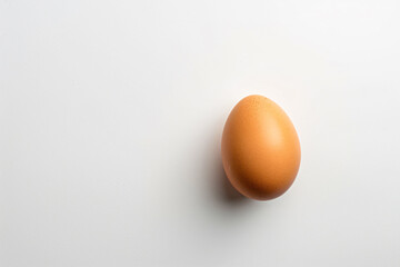 an egg on a white surface with a shadow