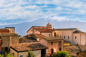 Obraz premium scenic view from a beautiful italian town to amazing buildings with church and roofs and picturesque highland mountain with nice blue cloudy sky on background