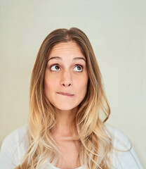 Face, woman and rolling eyes on portrait in studio background with unsure and uncertain. Female...