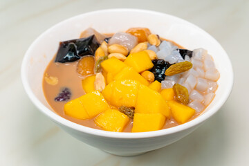 angle view bowl of milktea flavor syrup mixed with grass jelly and mangoes and peach gum and tapiocas and red beans and guiling jelly etc. at horizontal composition