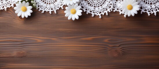 Top view of the process of hand crocheting of lace from white cotton yarn and a sprig of white flowers on a wooden background Hobbies and handicrafts in the summer DIY concept Flat lay close up