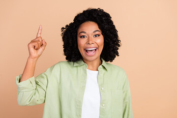 Photo of nice young woman point finger wear green shirt isolated on beige color background