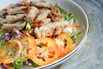 Fresh vegetable salad and pork steak